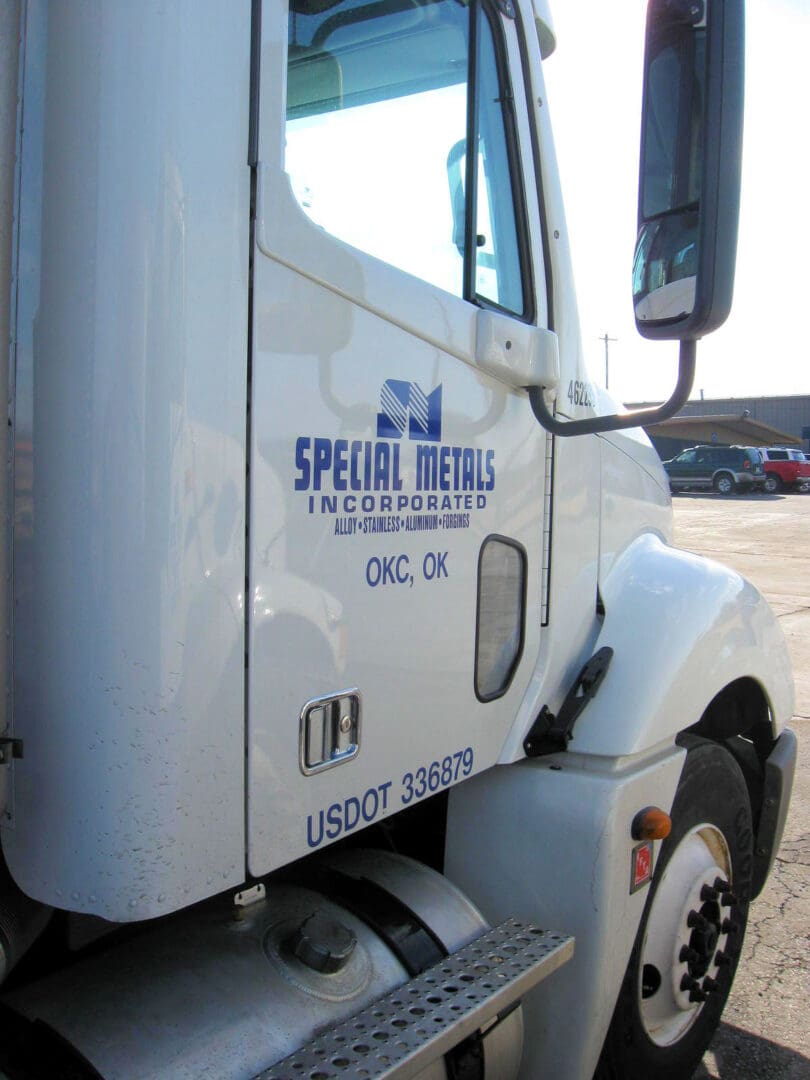 A white truck with blue lettering on the side.