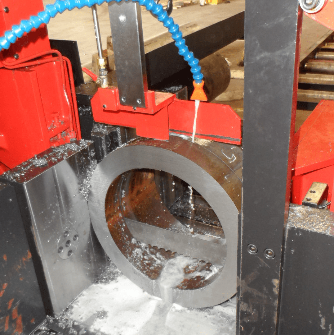 A machine is cutting metal with an electric saw.